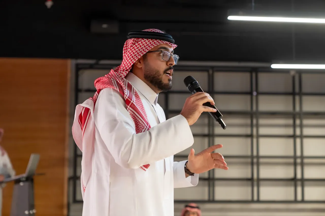 Fellowship participant speaking into a handheld microphone
